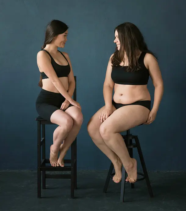 weight loss concept photo of two women side by side looking at each other smiling