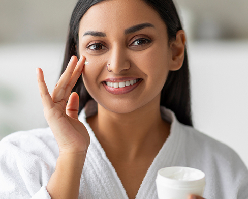 woman applying moisturizer
